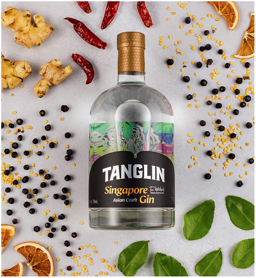 Tanglin Singapore Gin bottle, surrounded by ginger, chilli, juniper and kaffir lime